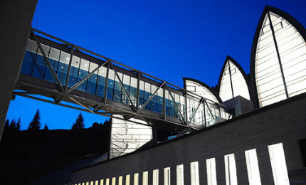 The suspended glass-encased bridge (the promenade architecturale) connecting the Bergoase wellness centre with the Tschuggen Hotel.
